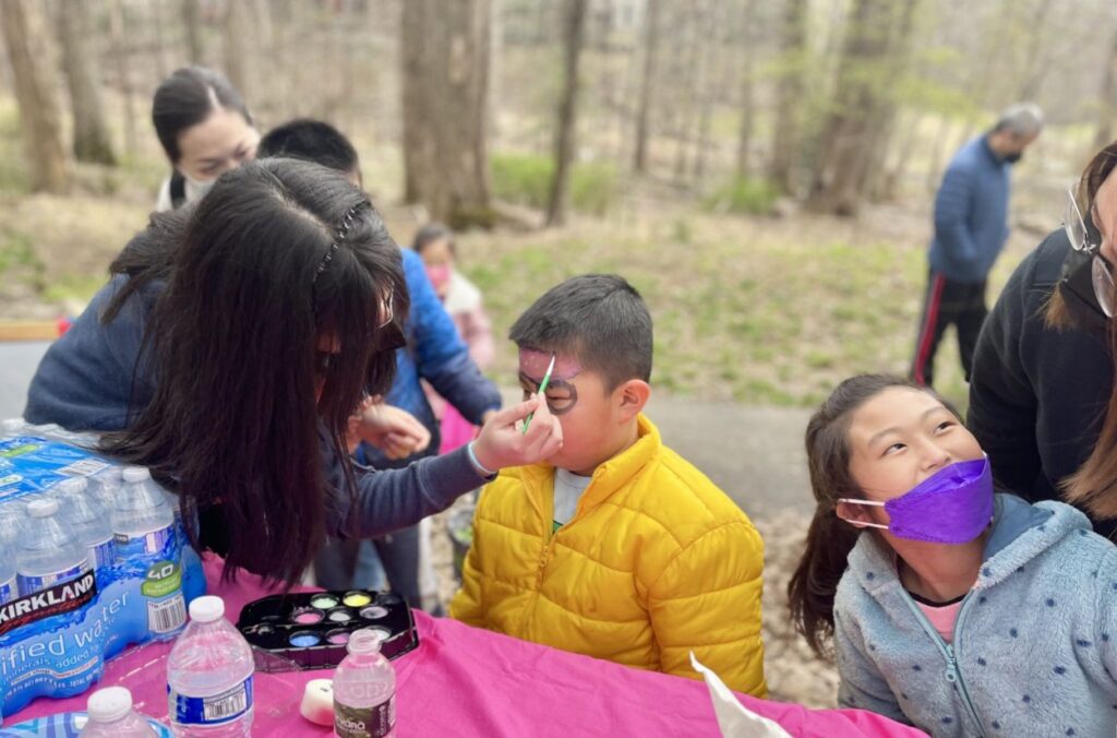 Students are outside getting their face painted.